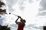A woman in action of the backswing with a golf club