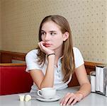 Jeune femme avec une tasse de café dans la salle à manger