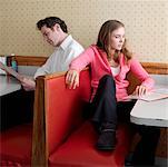 Young Woman and Young Man Studying Menus in Diner