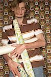 Young Man Holding Rolls Of Wallpaper