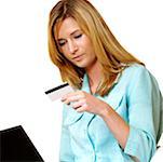 Businesswoman looking at a credit card on front of a laptop