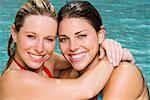 Portrait of two young women hugging in a swimming pool