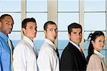 Side profile of four businessmen standing with a businesswoman