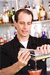 Close-up of a mid adult man preparing a cocktail