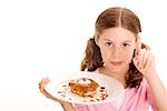 Portrait of a girl holding a donut in a plate with cream on the tip of her finger