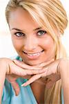 Portrait of a young woman smiling with her hand on her chin