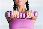 Close-up of a young woman holding dumbbells