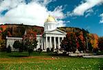 State Capitol in the fall with blue sky & colorful trees in the background, Montpelier, Vermont