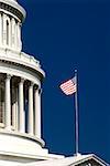 Low angle view of an American flag fluttering on a government building, Capitol Building, Washington DC, USA