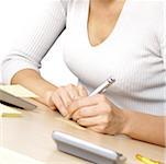 Mid section view of a businesswoman writing on paper
