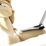 Mid section view of a businesswoman sitting with a laptop