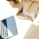 Mid section view of a businesswoman lying in front of a laptop