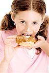 Portrait d'une jeune fille mangeant un beignet