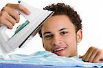 Portrait of a young man ironing his shirt