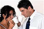 Close-up of a young woman and a mid adult man drinking coffee