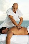 Nahaufnahme eines Massage-Therapeuten geben einem jungen Mann eine Rückenmassage