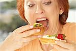 Close-up of a senior woman eating a fruit tart