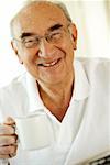 Portrait d'un homme senior tenant une tasse de café