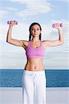 Portrait of a young woman exercising with dumbbells