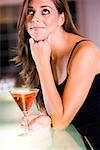 Side profile of a young woman leaning over a bar counter