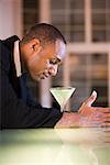 Side profile of a businessman with a martini in front of him