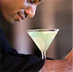 Side profile of a businessman with a martini in front of him