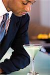 Close-up of a businessman looking at a glass of martini