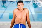 Portrait of a young man sitting at the poolside