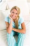 High angle view of a young woman sitting on a bed