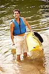 Vue d'angle élevé d'un homme adult moyen tenant un kayak et l'aviron