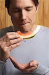 Homme manger pastèque