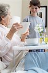 Grandson Serving Grandmother Breakfast in Bed