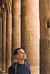 Homme regardant hiéroglyphiques colonnes, Temple de Philae, Assouan, Égypte