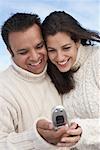 Couple Looking At Photo On Cell Phone
