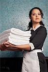 Maid Carrying Stack of Towels