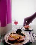 Person holding a spoon over a plate of steak and beans