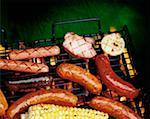 High angle view of sausages and corn on a barbecue grill