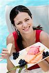 Portrait of a young woman holding food in a tray