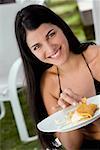 Porträt einer jungen Frau hält einen Teller mit Essen
