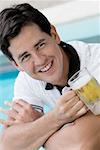 Close-up of a young man holding a beer glass