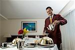 Waiter pouring tea in a cup