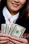 Close-up of a businesswoman holding one hundred dollar bills