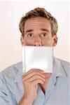 Portrait of a mid adult man holding a CD case in front of his mouth