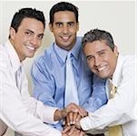 Portrait of three businessmen shaking hands