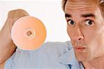 Portrait d'un homme adult moyen avec un CD sur son doigt