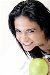 High angle view of a young woman holding a green apple