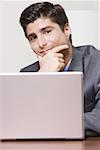 Portrait of a businessman sitting in front of a laptop