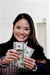 Portrait of a businesswoman holding one hundred dollar bills