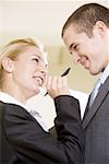 Low angle view of a businesswoman holding a pen in front of a businessman