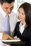 Close-up of a businessman dictating notes to his secretary